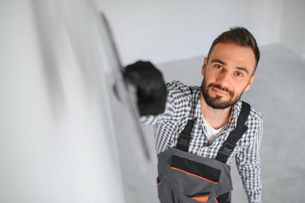 Junger Arbeiter führt Reparaturen im Zimmer durch