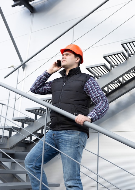 Junger Architekt telefoniert bei der Inspektion der Fabrik