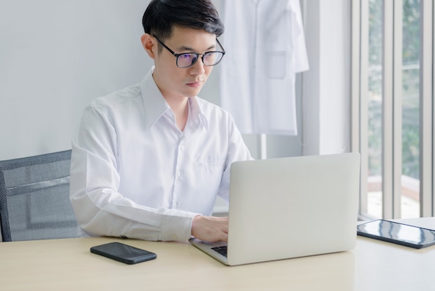 Junger Arzt, der im Büro arbeitet