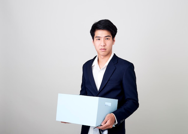 Junger asiatischer Geschäftsmann, der eine Box hält