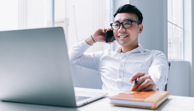 Junger asiatischer Geschäftsmann, der im Büro arbeitet