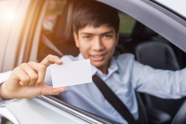 Junger asiatischer Geschäftsmann, der im modernen Auto sitzt