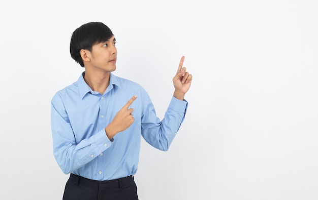 Junger asiatischer Geschäftsmann mit dem blauen Hemd, das zur Seite mit einer Hand zeigt, um ein Produkt oder eine Idee lokalisiert auf weißem Hintergrund zu präsentieren.