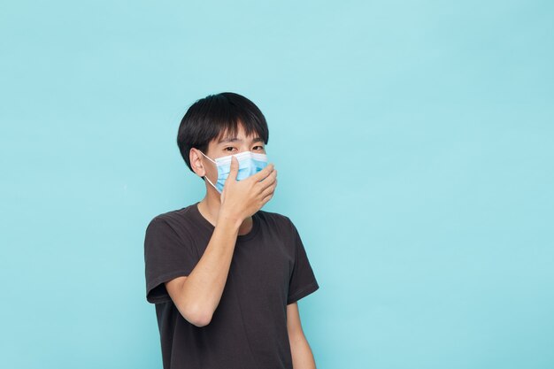 Junger asiatischer Mann, der eine Gesichtsmaske trägt