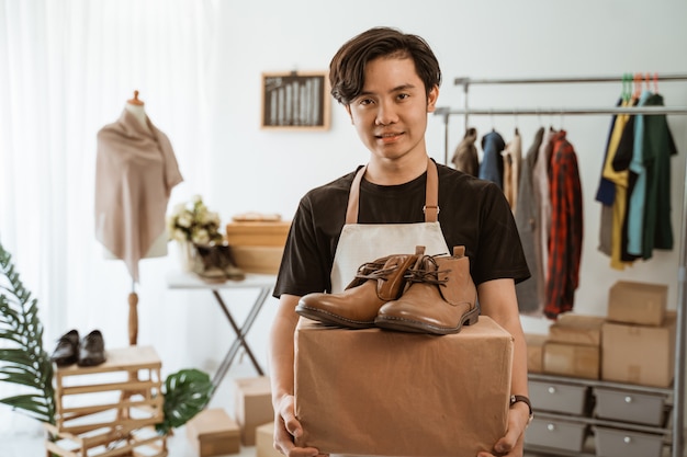 Junger asiatischer Mann, der in einem Bekleidungsgeschäft arbeitet