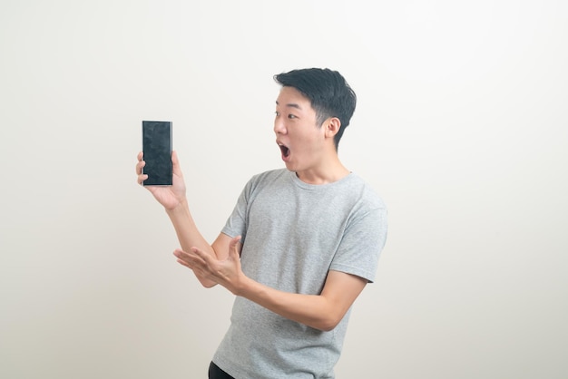 Junger asiatischer Mann, der Smartphone und Handy verwendet oder spricht