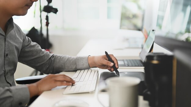 Junger asiatischer Mann, der von zu Hause an einem Computer arbeitet