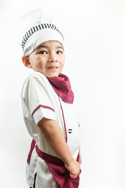 Junger asiatischer Mann, gekleidet wie ein Koch, der sich auf das Kochen vorbereitet Porträt eines glücklichen süßen männlichen Kinderkochs