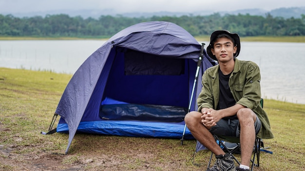 Junger asiatischer Mann genießen Camping am Reservoir