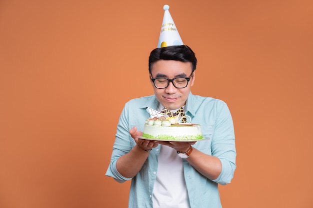 Junger asiatischer Mann mit Geburtstagstorte
