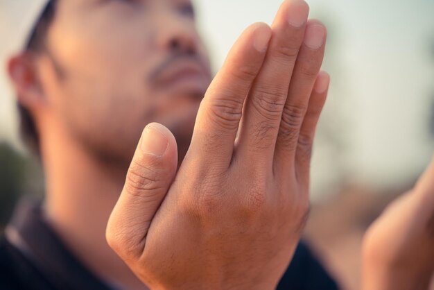 Junger asiatischer muslimischer Mann, der bei Sonnenuntergang betet Ramadan-Festival-KonzeptThailänderSegen von Allah