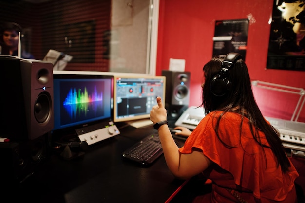 Foto junger asiatischer sängermann mit mikrofonaufnahmelied im plattenmusikstudio mit tonproduzent.