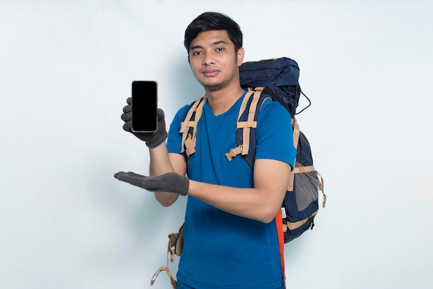Junger asiatischer sportlicher Mann, der Handy auf weißem Hintergrund demonstriert