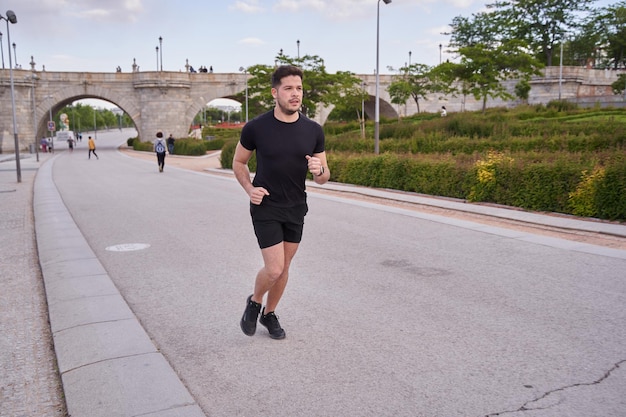 junger Athlet, der auf der Stadtstraße trainiert, athletischer Mann, der rennt