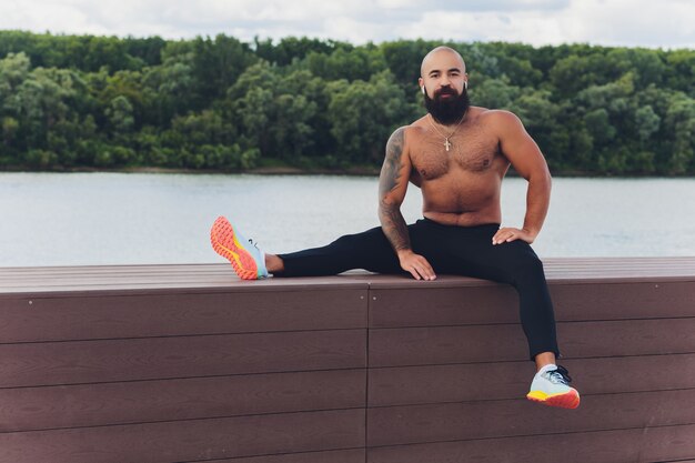 Junger Athlet, der draußen schnell läuft. Sportkleidung tragen, breiten Schritt machen, gesunde Lebensweise demonstrieren, Weitschuss.