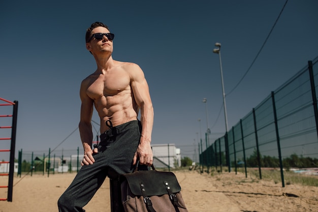 Junger Athlet mit einem schönen Körper, der vor der Kamera posiert, Outdoor-Training hochwertiges Foto