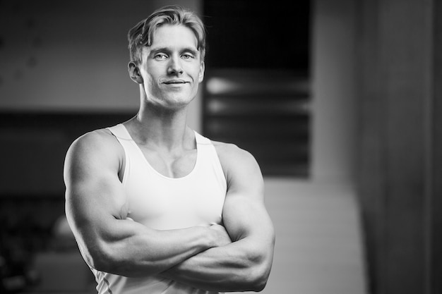 Junger athletischer Mann, der beim Training Muskeln im Fitnessstudio aufpumpt Sport- und Gesundheitskonzept