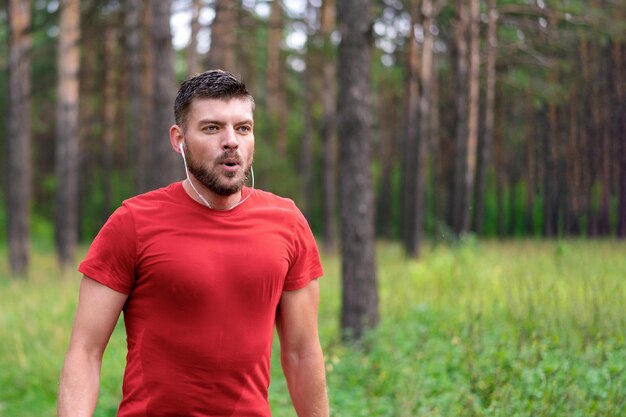 Junger athletischer Mann, der im Park joggt