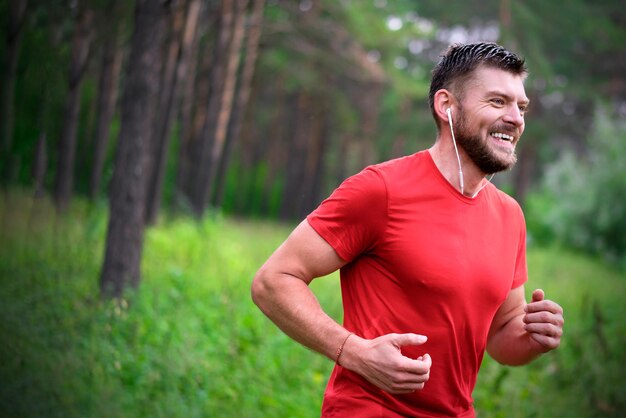 Junger athletischer Mann, der im Park joggt