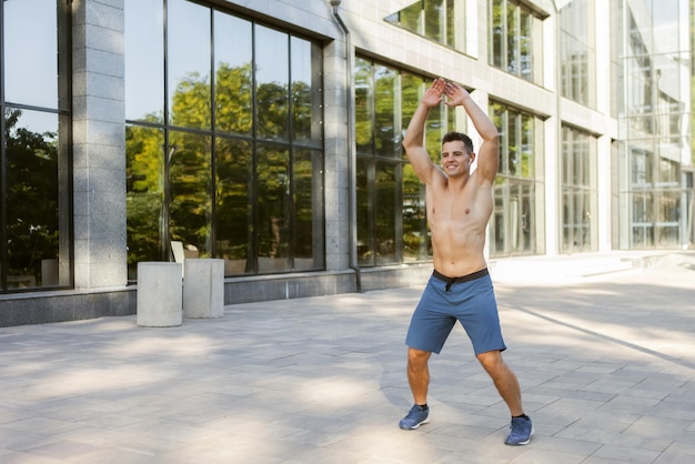 Junger athletischer Mann, der sich vor dem Training im Freien aufwärmt. Gesunder Lebensstil. Fitnesskonzept
