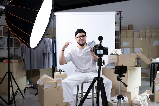 Junger attraktiver asiatischer Mann, Blogger oder Vlogger, der in die Kamera schaut, um das Produkt zu überprüfen