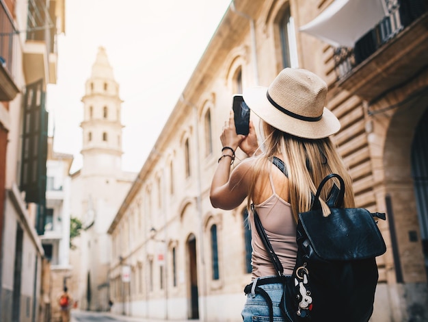 Foto junger attraktiver lächelnder mädchen-tourist, der neue stadt im sommer erkundet