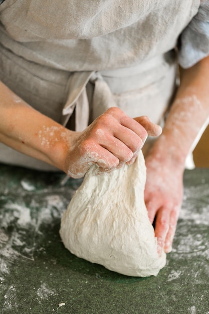 Junger Bäcker, der handwerkliches Sauerteigbrot zubereitet.