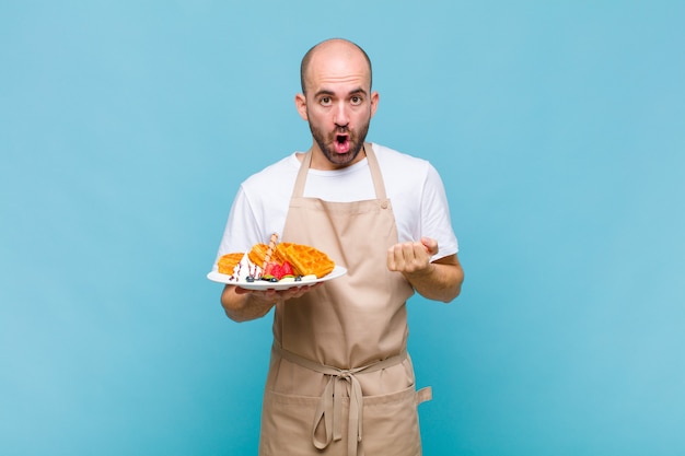 Junger Bäcker mit Waffeln