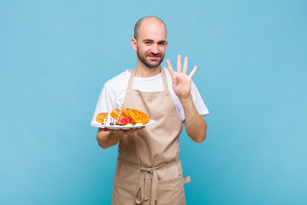 Junger Bäcker mit Waffeln