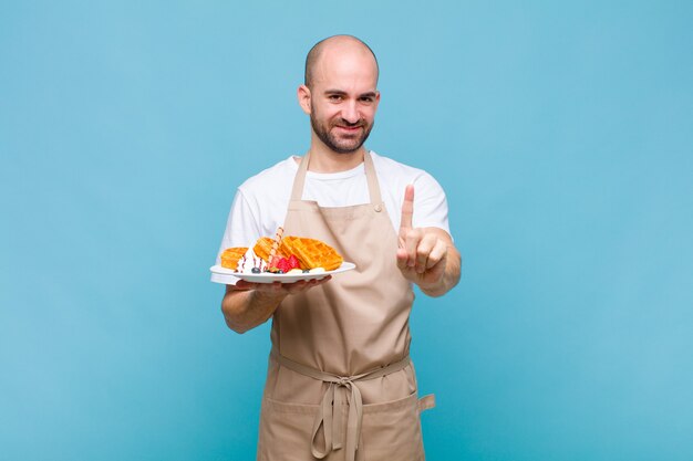 Junger Bäcker mit Waffeln