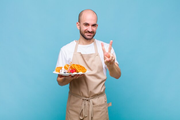 Junger Bäcker mit Waffeln