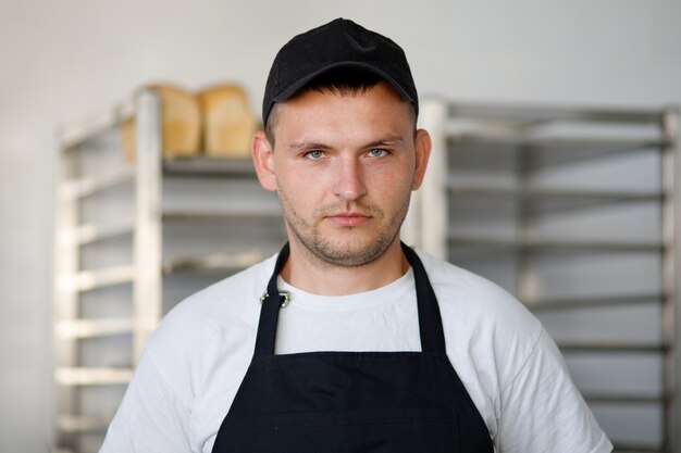 Foto junger bäckerarbeiter in einer bäckerei in uniform