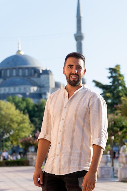 Junger bärtiger Mann, der bei Sonnenuntergang mit der Blauen Moschee im Hintergrund posiert