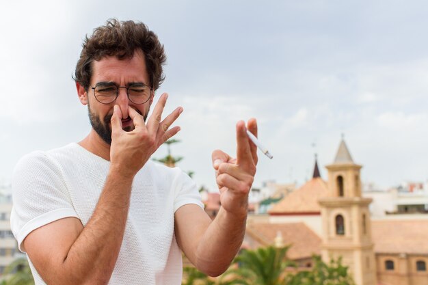 Foto junger bärtiger mann, der eine zigarette raucht