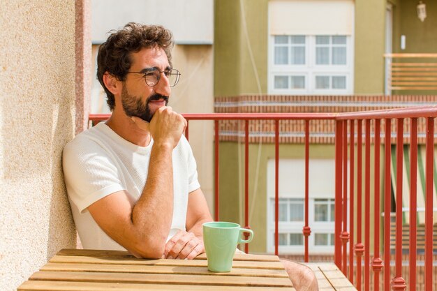 Junger bärtiger Mann, der einen Kaffee trinkt