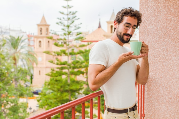 Junger bärtiger Mann, der einen Kaffee trinkt