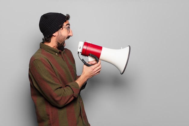 Junger bärtiger Mann, der mit einem Megaphon protestiert