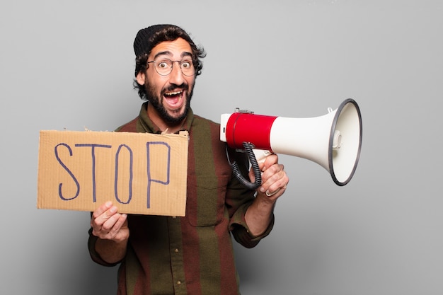 Junger bärtiger Mann, der mit einem Megaphon protestiert