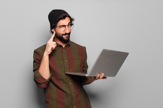 Junger bärtiger Mann mit einem Laptop