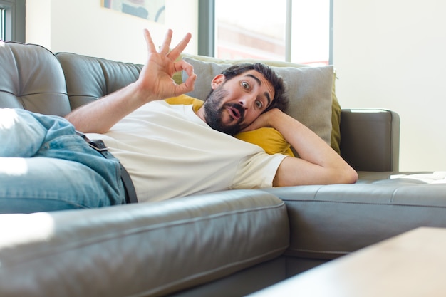 Junger bärtiger Mann ruht auf einer Couch