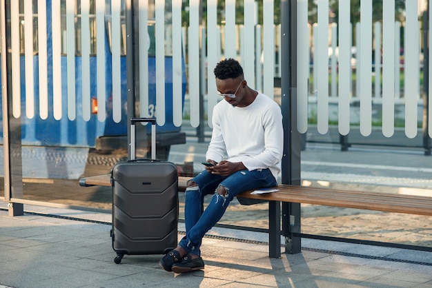 Junger bärtiger Mann Tourist mit Rucksack und Smartphone