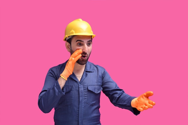 junger Bauarbeiter posiert über rosa Hintergrund indisches pakistanisches Modell