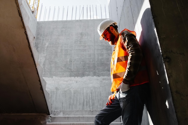 Junger Bauunternehmer steht an seinem Arbeitsplatz auf der Baustelle