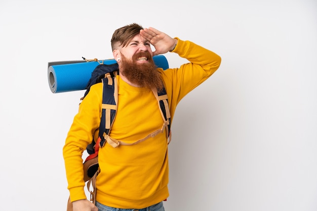 Junger Bergsteigermann mit einem großen Rucksack über weißer Wand