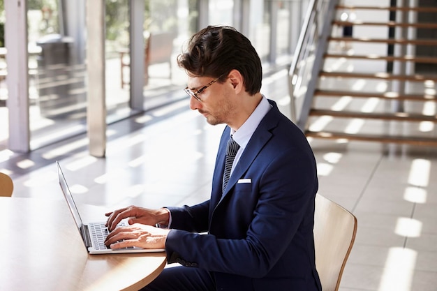 Junger Berufsmann, der erhöhte Ansicht des Laptops verwendet