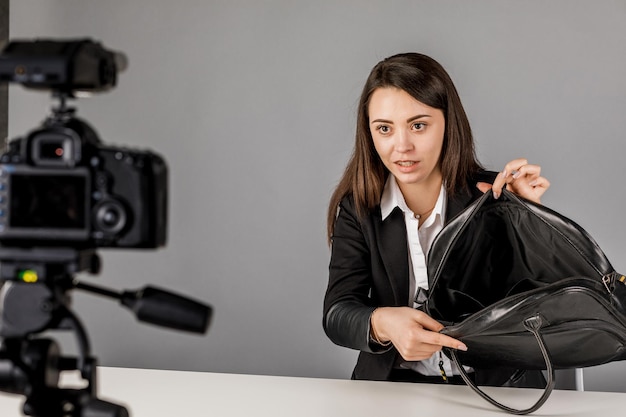 Junger Blogger in dunkler Suite auf grauem Hintergrund