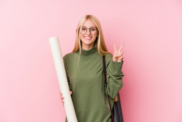 Junger blonder Architekturstudent, der Nummer zwei mit den Fingern zeigt.