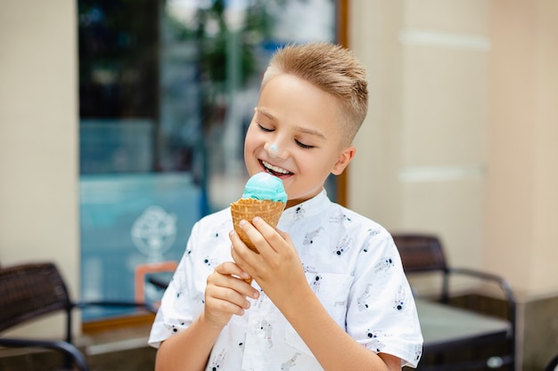 Junger blonder Junge mit Eiscreme in seinen Händen