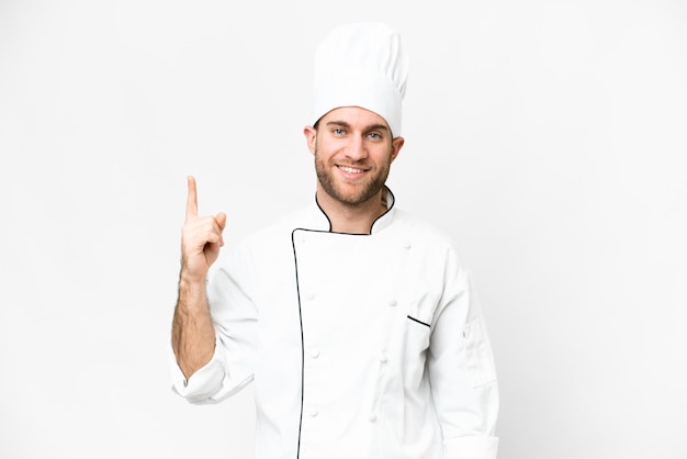 Junger blonder Mann Koch über isoliertem weißem Hintergrund, der einen Finger im Zeichen der Besten zeigt und hebt