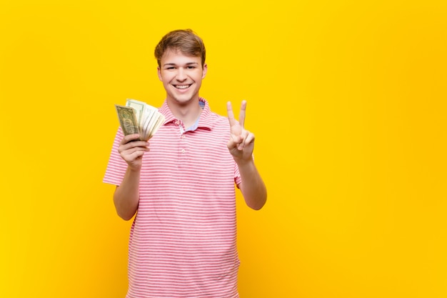 Junger blonder Mann mit Dollarbanknoten